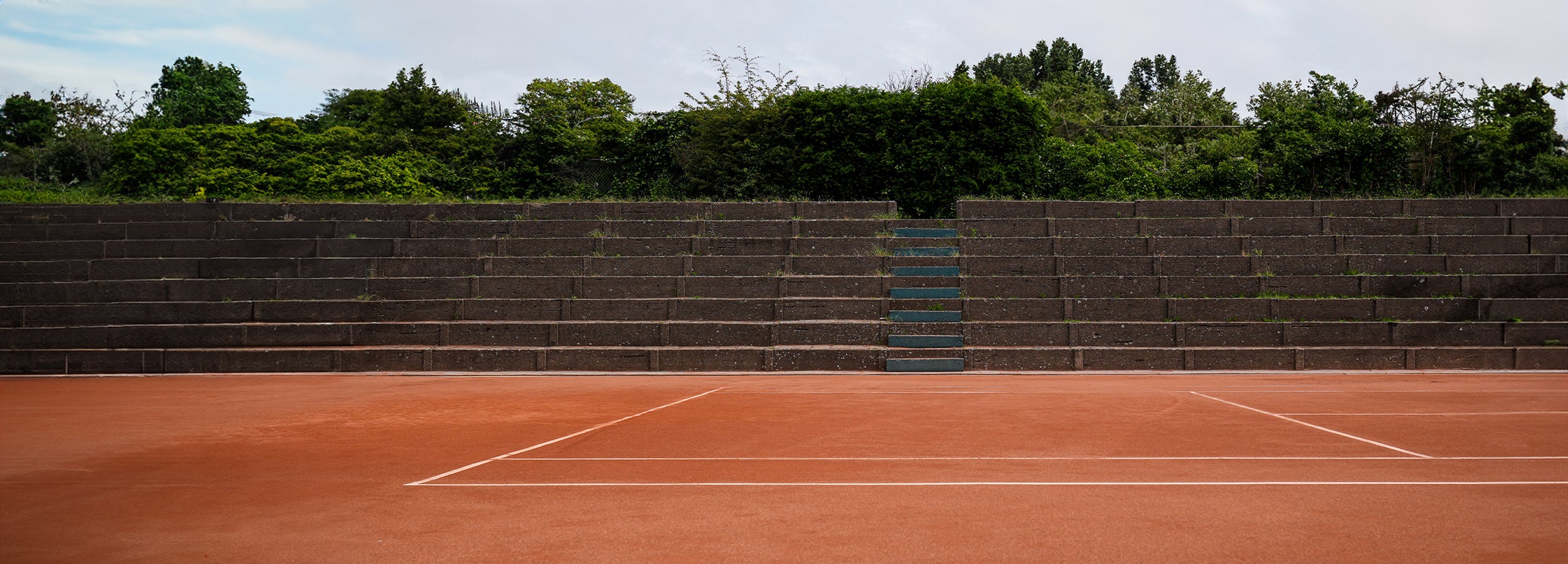 The ACE Hub tennis heritage reference – abandoned clay court with mid-century style bleachers