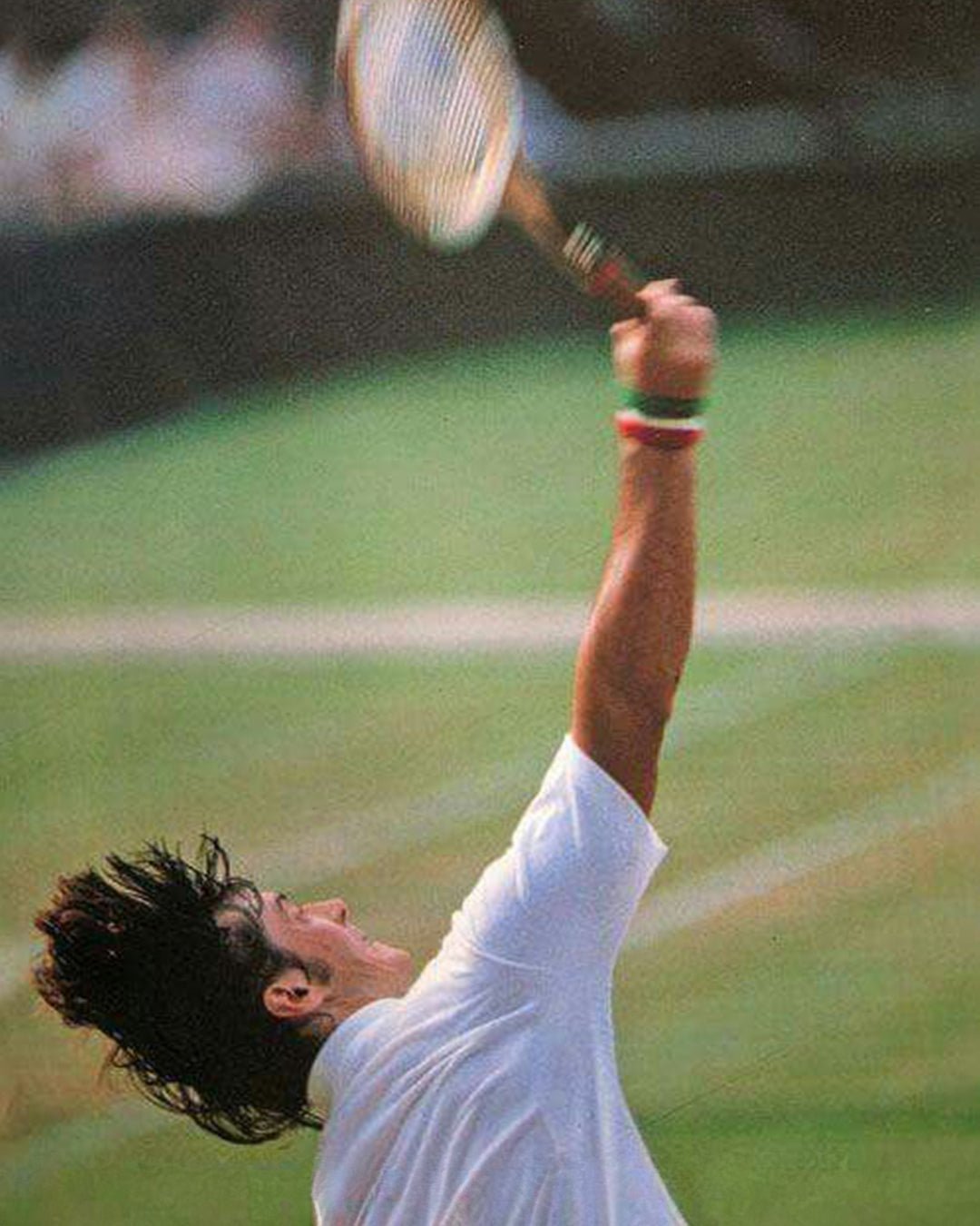 Adriano Panatta serving on grass court