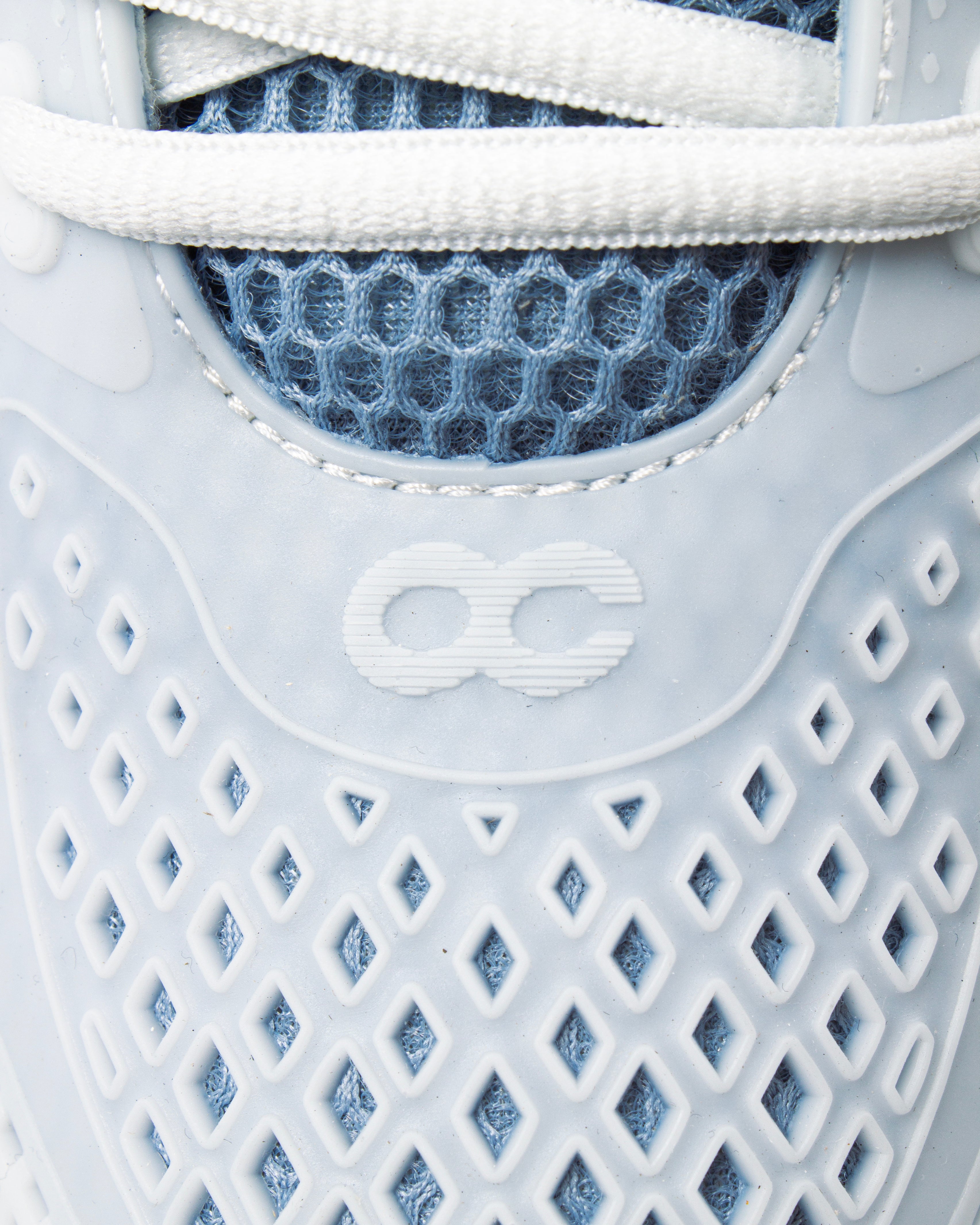 Detail view of the ACE 25 performance tennis sneaker – OC logo and breathable mesh
