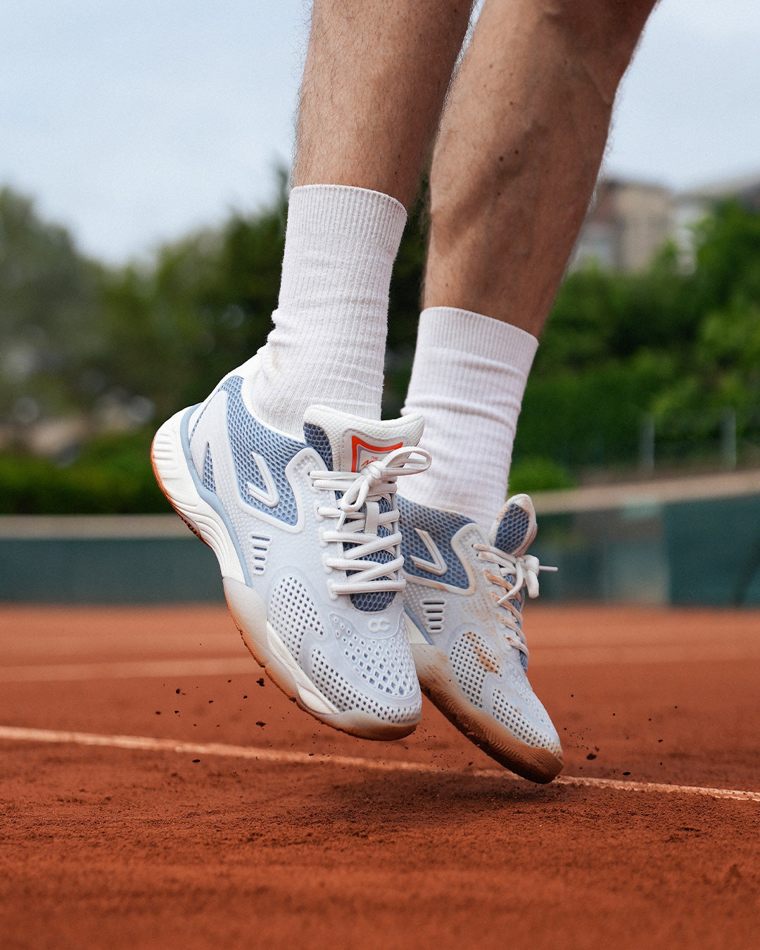 The ACE Hub OC sneaker in sea ice white, jumping on court at De Mets The Hague

