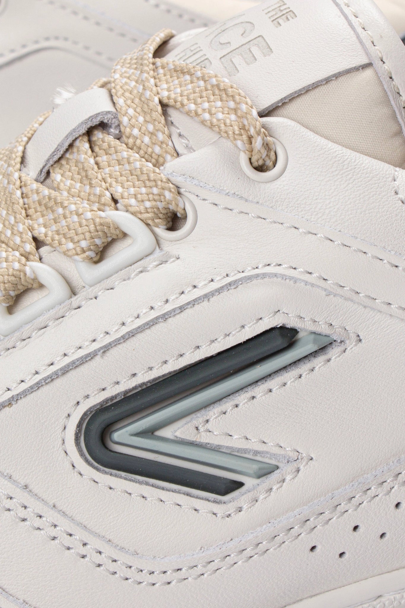 Close-up of The ACE Hub Sprint sneaker in off-white and cucumber leather with logo detail